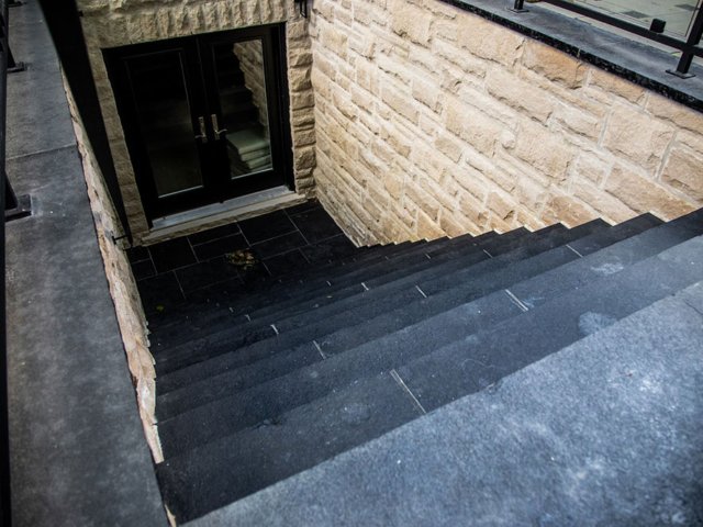 Backyard patio steps going into the walkout basement using jet black natural stone