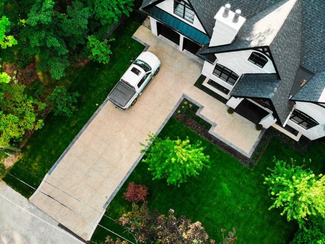 Driveway paved with exposed aggregate concrete accented by stamped concrete around the border