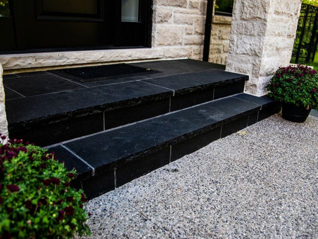 Front entrance with jet black pavers in a wet lay application, and set in concrete with mortared joints